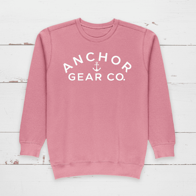 A pink crewneck sweatshirt with 'ANCHOR GEAR CO.' written in white on the front.