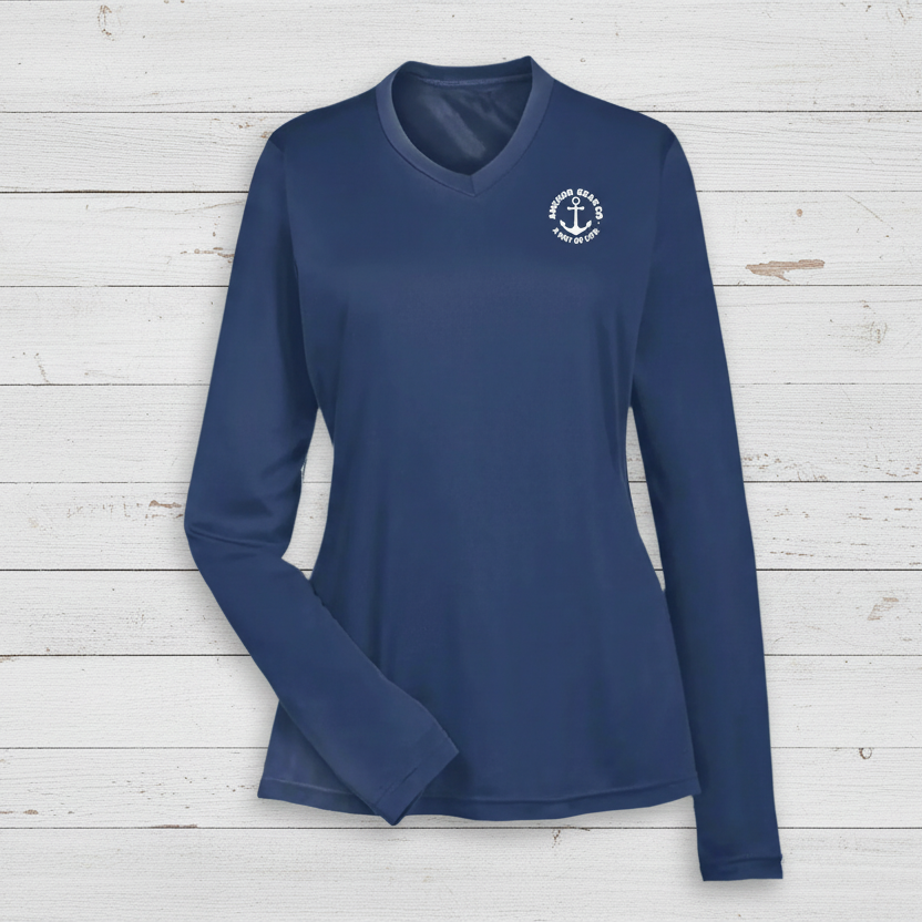 A navy blue long sleeve performance shirt for women with a unique anchor design on the chest, displayed against a white backdrop
