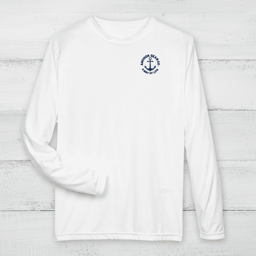 A white long sleeve performance shirt with a anchor design on the chest, displayed on a off white background