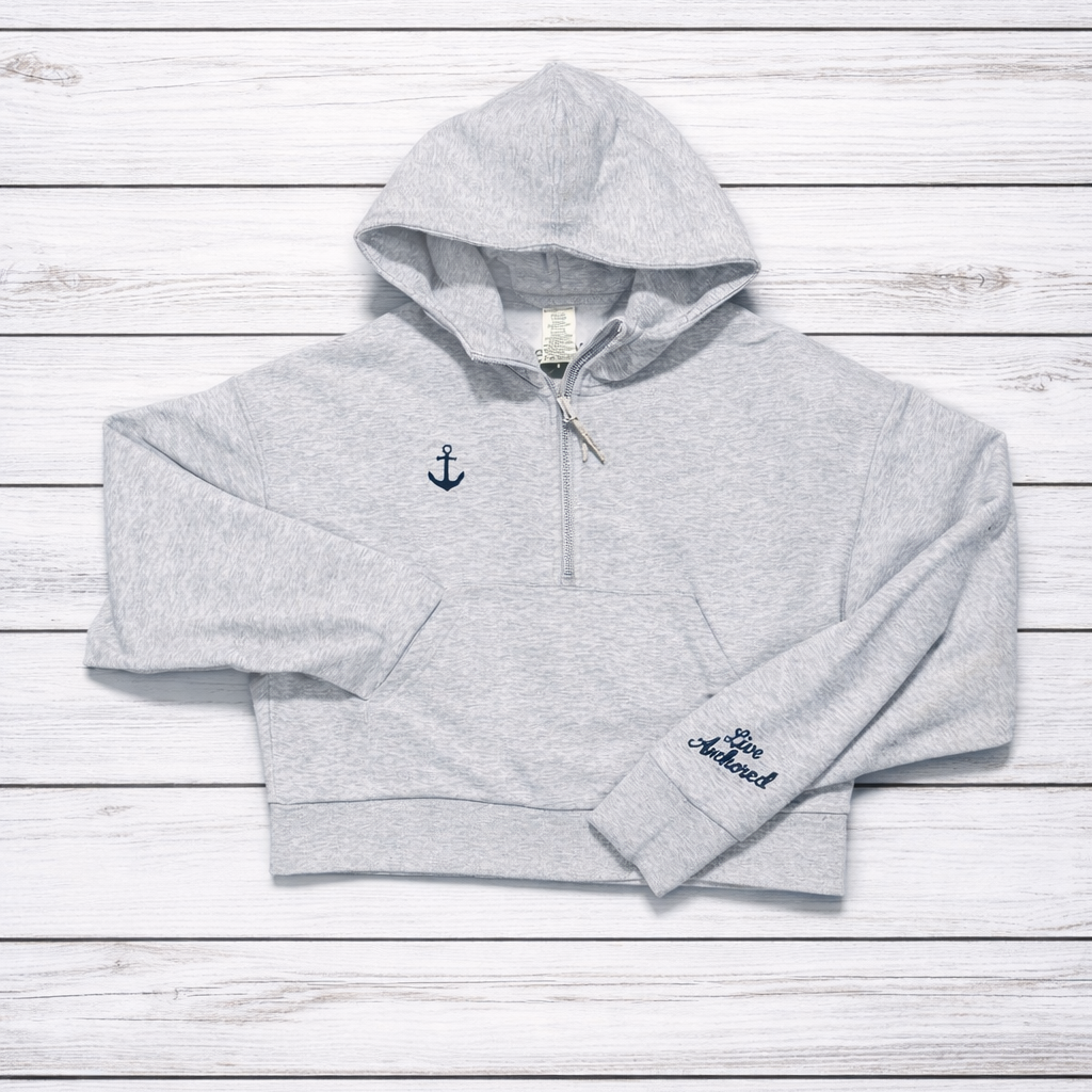 Gray hoodie with anchor design on a wooden surface