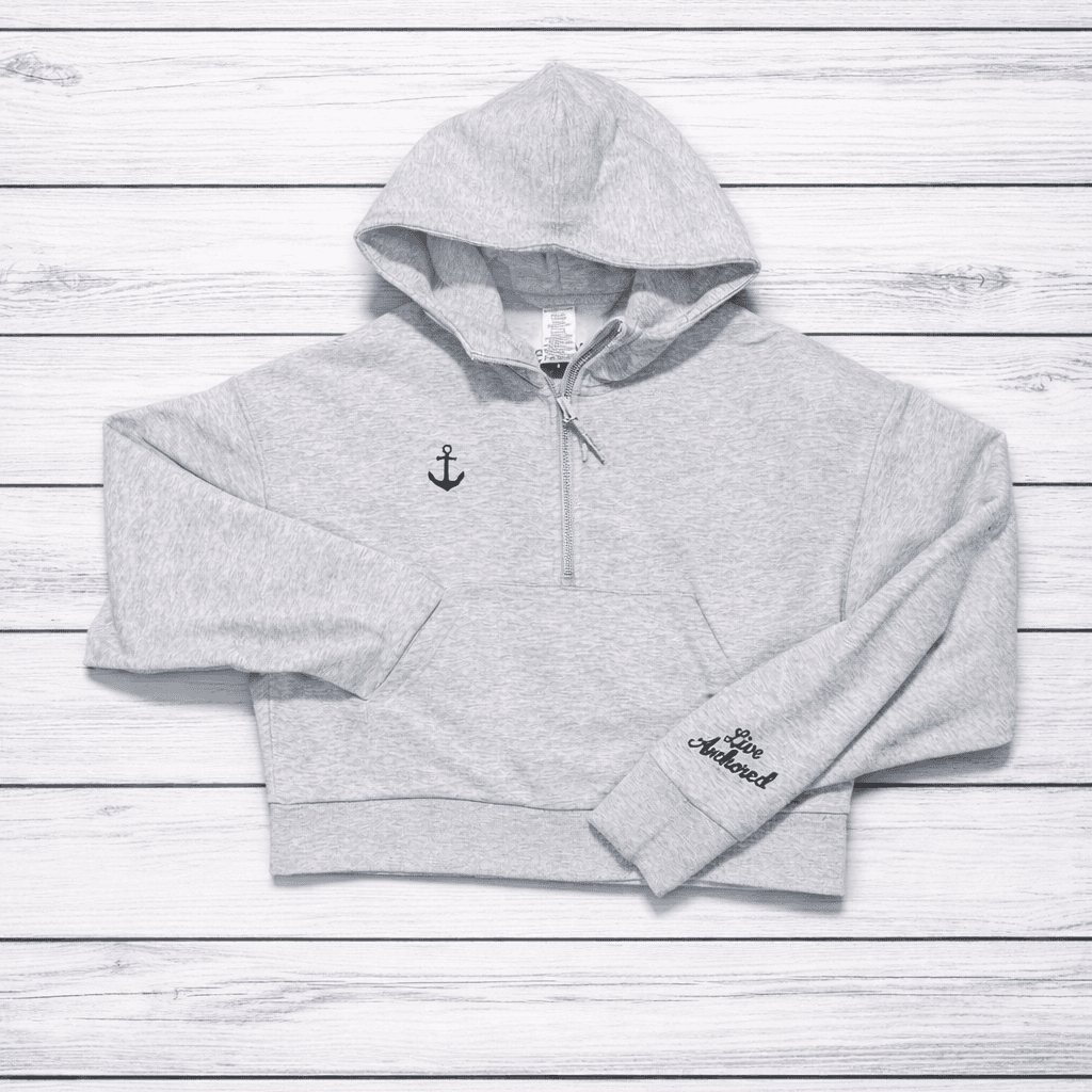 Gray hoodie with anchor design on a wooden surface