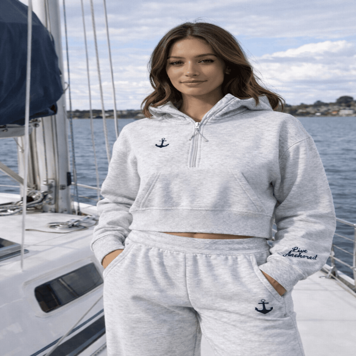 Woman wearing a gray hoodie and pants with anchor designs on a boat