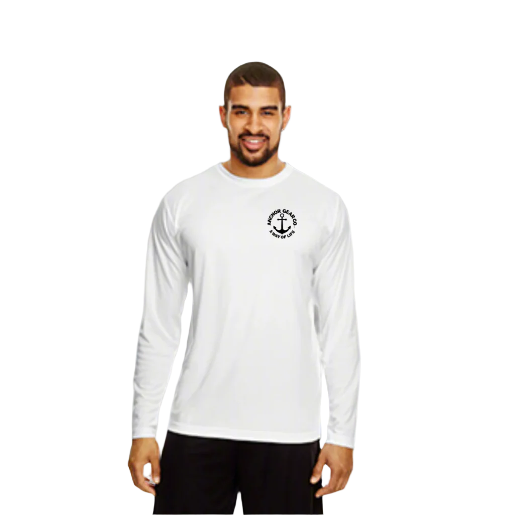 A man standing by a body of water wearing a blue long sleeve UV shirt with a white anchor logo on the chest.