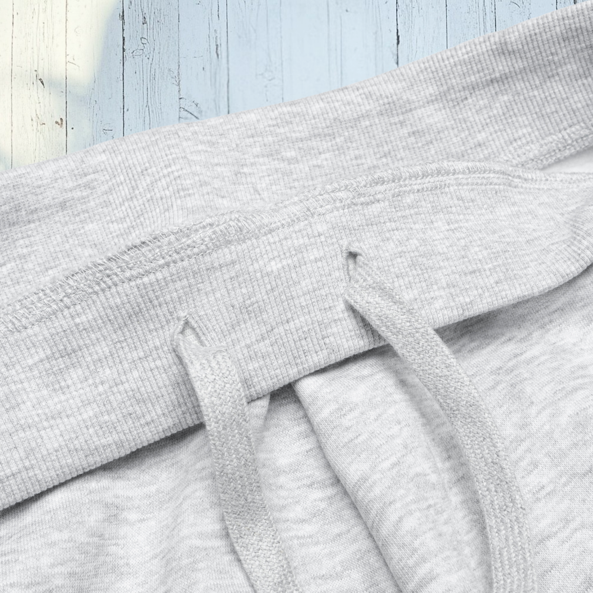 Close-up of gray textured fabric with a wooden surface background