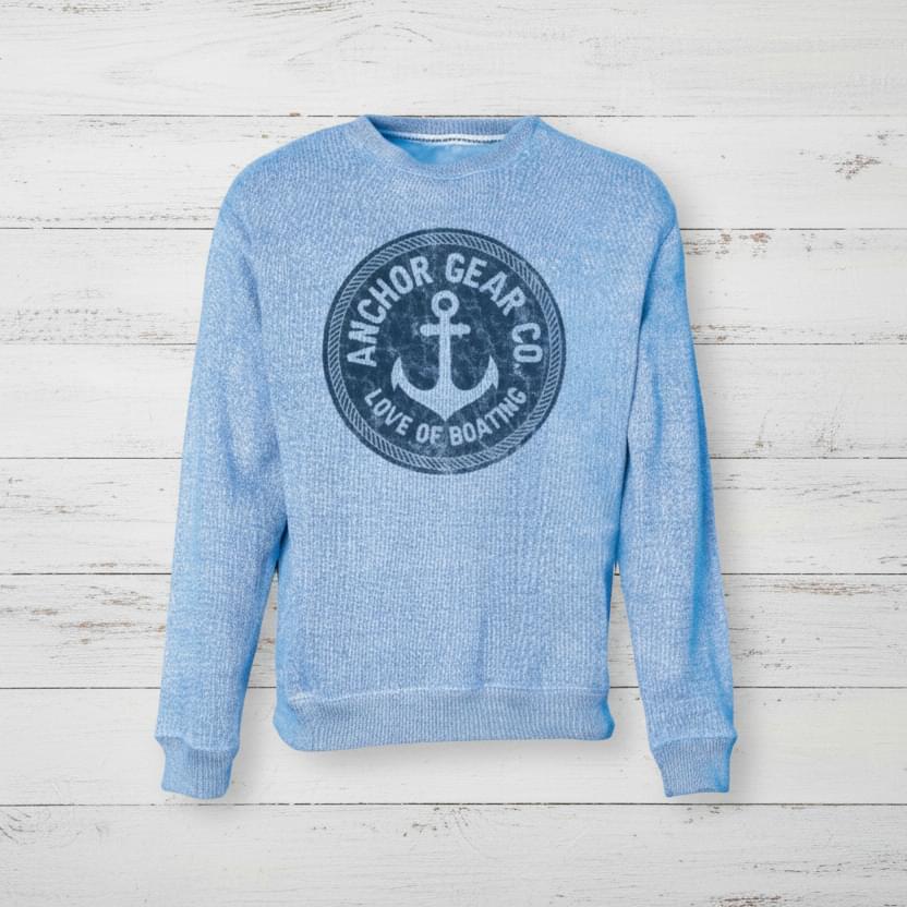 Blue sweatshirt with anchor logo on a wooden surface