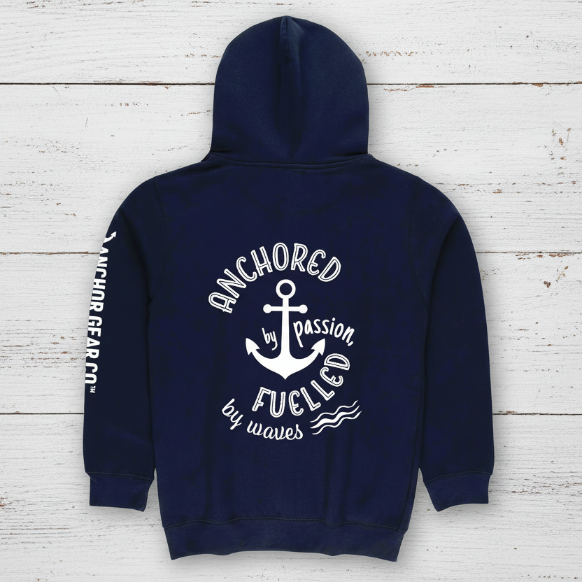 A navy blue full zip hoodie with the Anchor Gear Co. logo and the phrase 'Anchored by Passion, Fuelled by Waves' on the back, displayed against a lakeside backdrop.