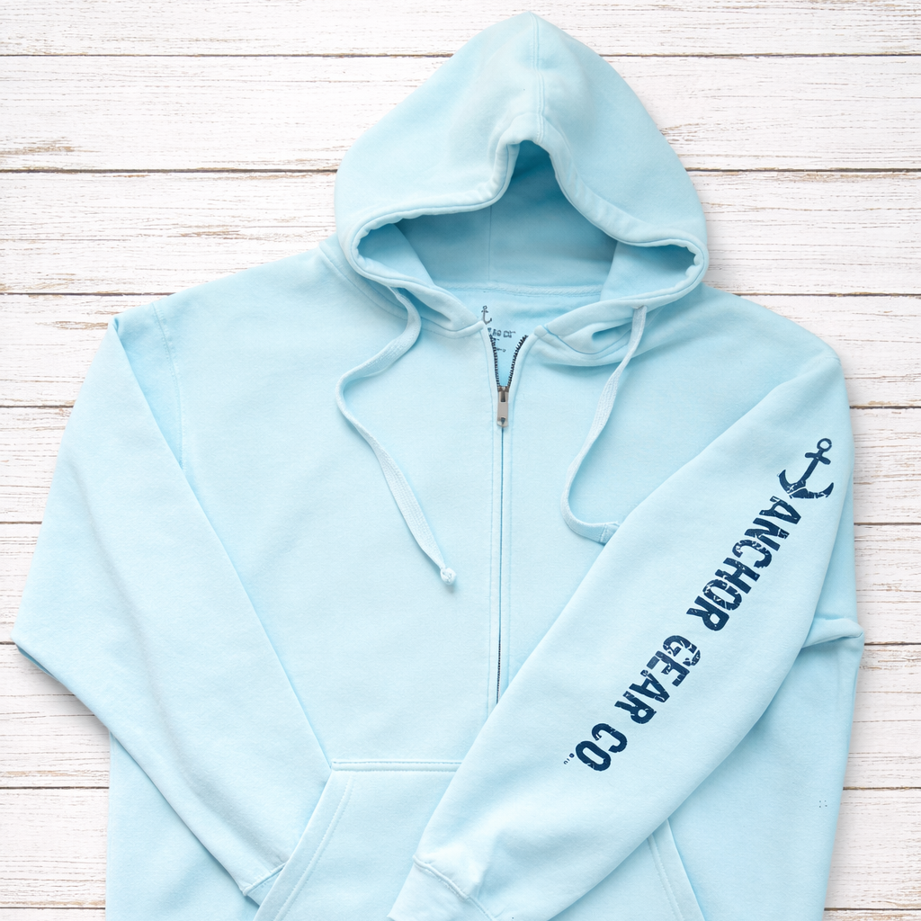 Light blue hoodie with a brand logo on a wooden surface
