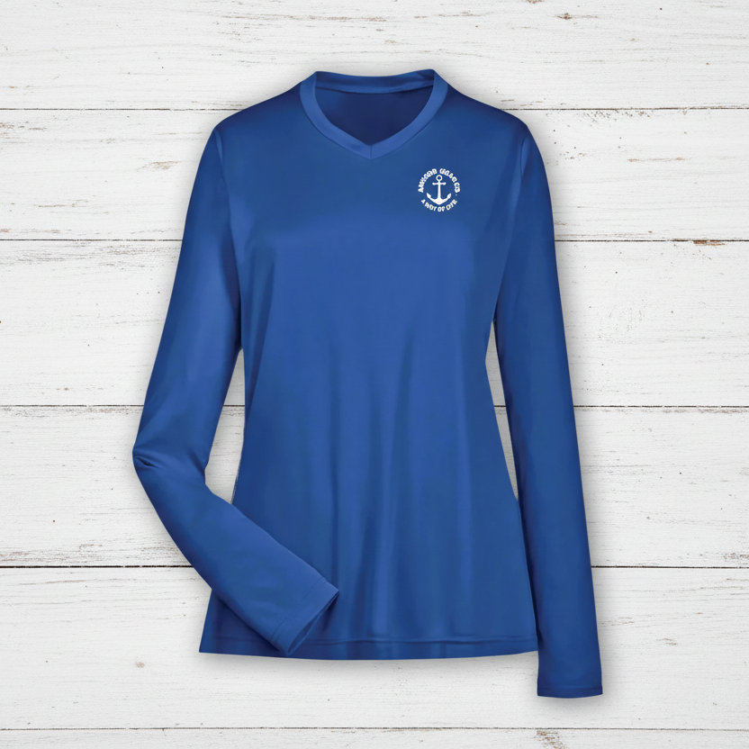 A royal blue long sleeve performance shirt for women with a unique anchor design on the chest, displayed against a white back drop