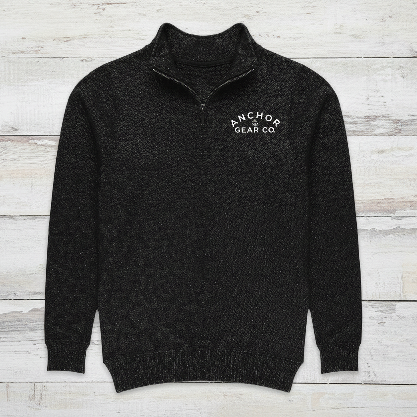Black sweater with 'Anchor Gear Co.' logo on a wooden dock with a blurred natural background