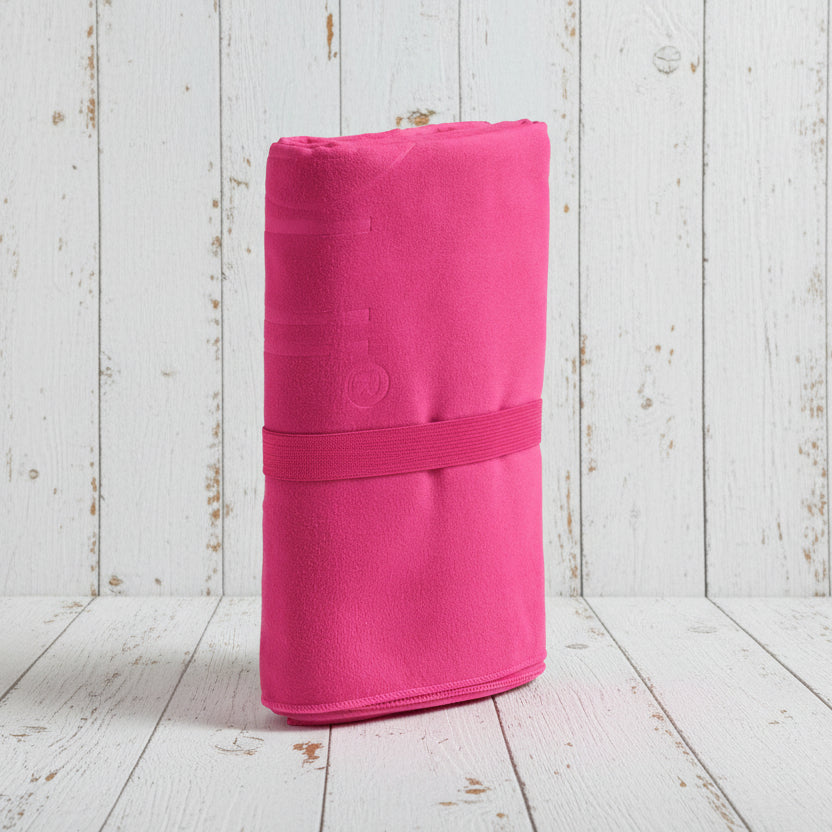 Pink rolled-up mat with a strap on a light gray background