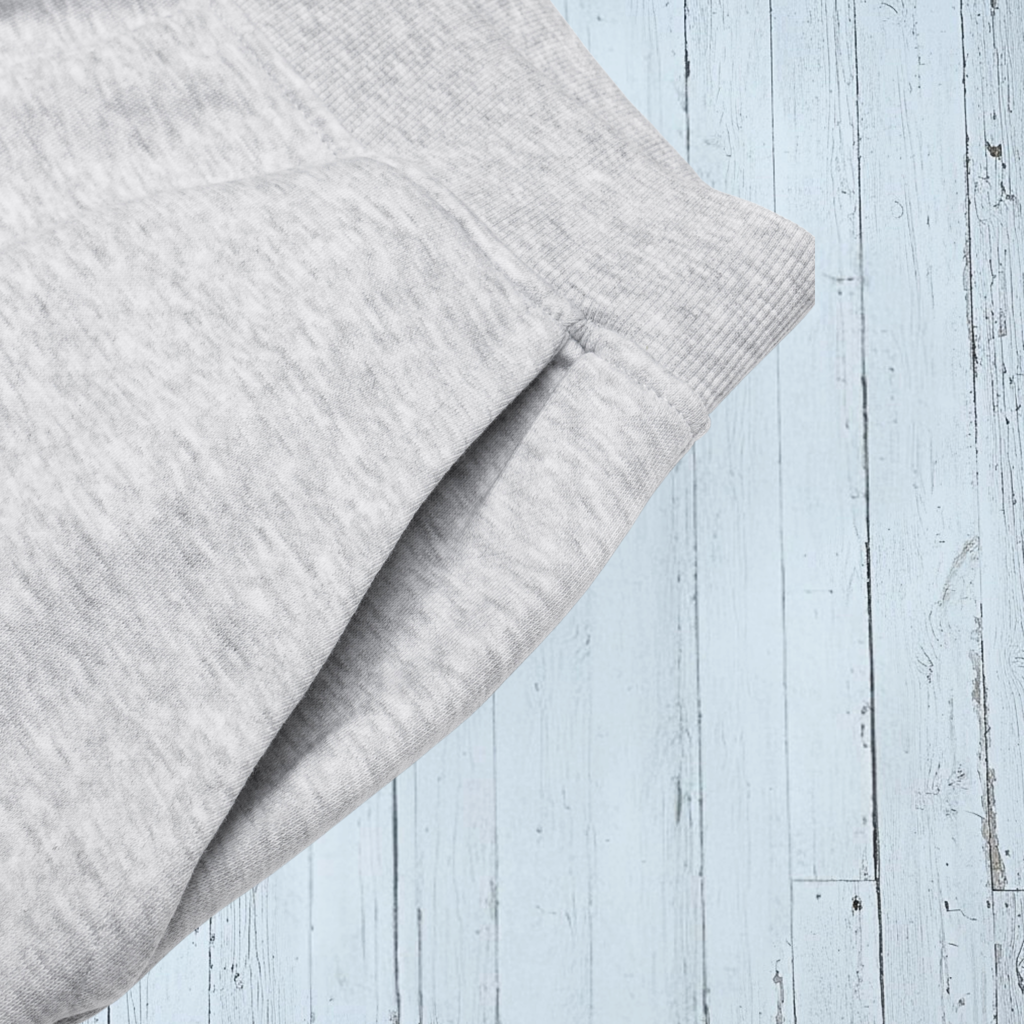 Gray textured fabric on a light blue wooden surface
